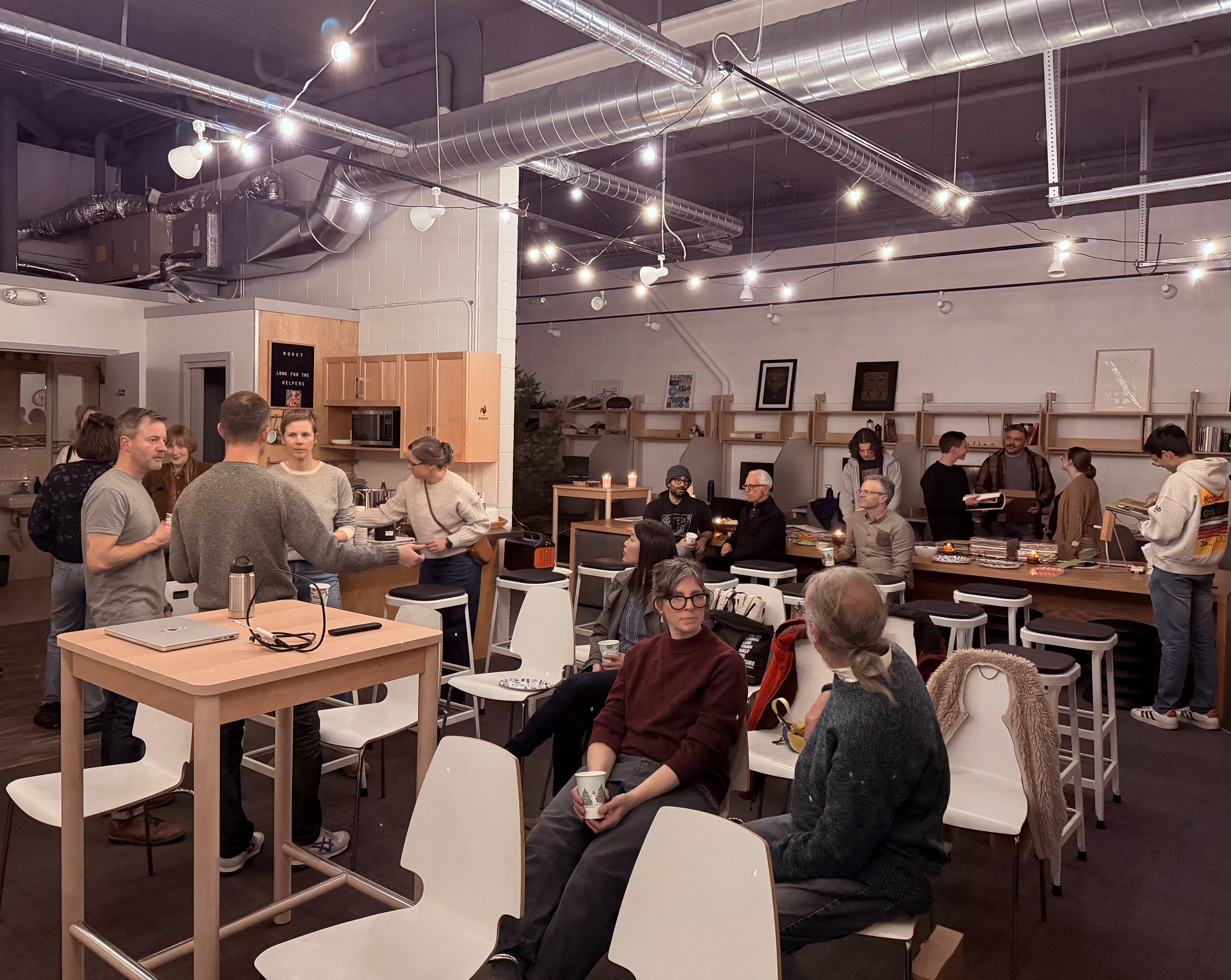 Roost coworking studio — a full room of members at an evening gathering